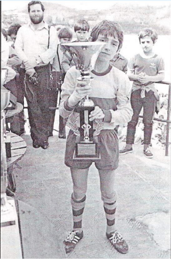 Un chavalín Txema Indias recoge un trofeo conquistado por su equipo en uno de los muchos torneos organizados en la Plata de la Concha